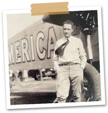 The vintage image of a man standing Infront of an American plane